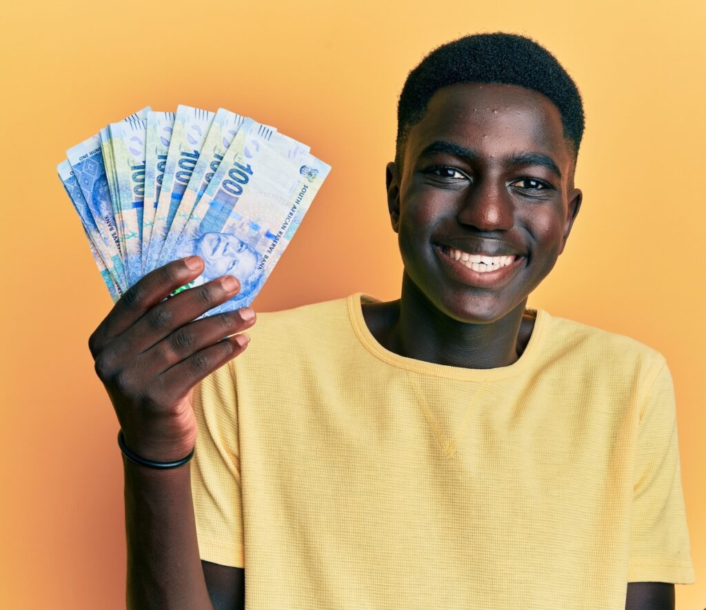 Financially fit young man holding hundred rand notes